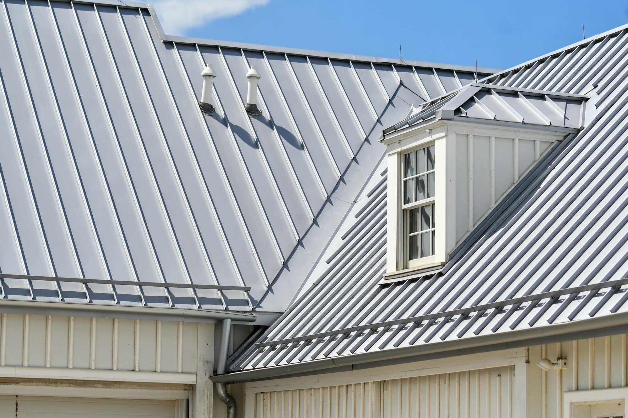 Standing seam metal roof, dormer and siding on a residential exterior